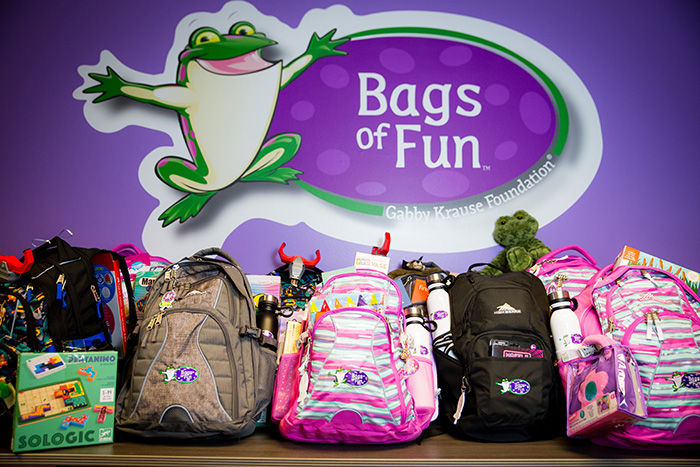 Bags of Fun volunteer groups holding backpacks and toys.